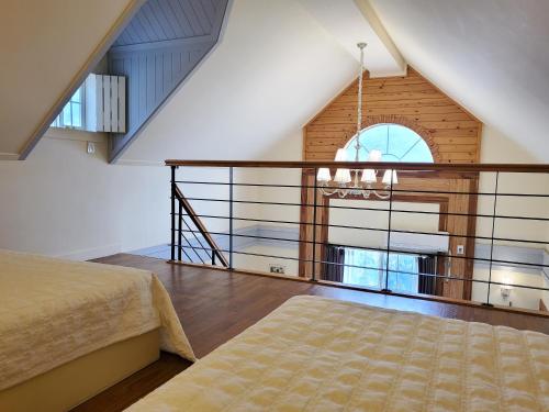 a bedroom with a bed and a large window at Olive Vanilla Pension in Gyeongju