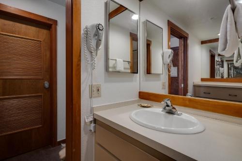ein Bad mit einem Waschbecken und einem Spiegel in der Unterkunft Lakeside 1481 in Keystone