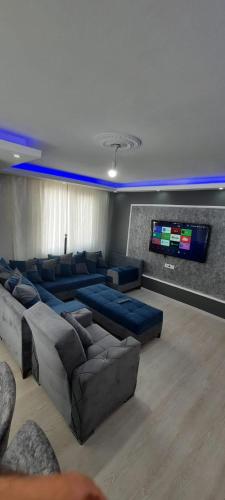 uma sala de estar com sofás e uma televisão de ecrã plano em شقة مفروشة للايجار باسطنبول em Basaksehir