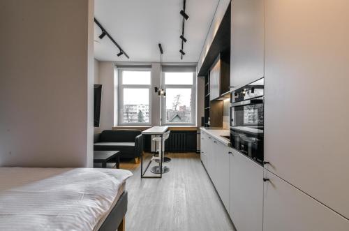 a room with a bed and a kitchen with a table at Apartments near Ozas in Vilnius