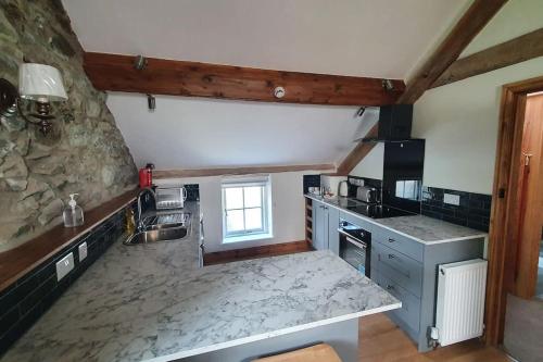 a kitchen with a sink and a counter top at The Hayloft Llwyndu in Barmouth