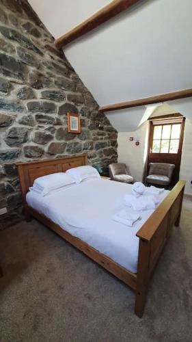 a bedroom with a large bed in a stone wall at The Hayloft Llwyndu in Barmouth