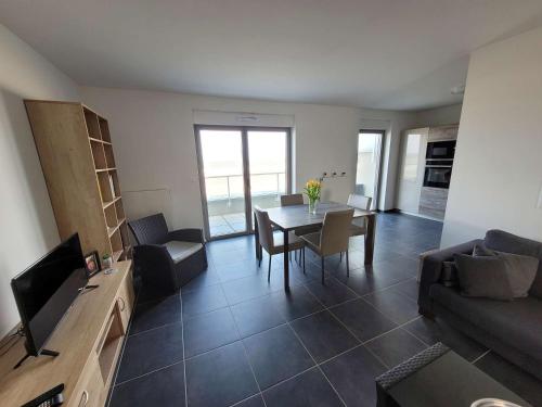 un salon avec une table et un canapé dans l'établissement Grand T3 vue mer avec balcon et parking, accès direct plage - FR-1-674-1, à Berck-sur-Mer