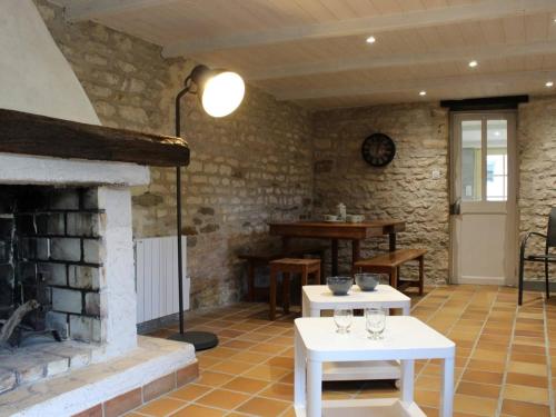 - un salon avec une cheminée et des tables blanches dans l'établissement Maison Charme Ancien, Jardin, 2Km Centre St Pierre, 20min Plage - 5 Couchages - FR-1-246A-65, à Saint-Pierre-dʼOléron