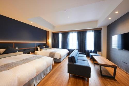 una camera d'albergo con due letti e un divano di HOTEL SAILS ad Osaka