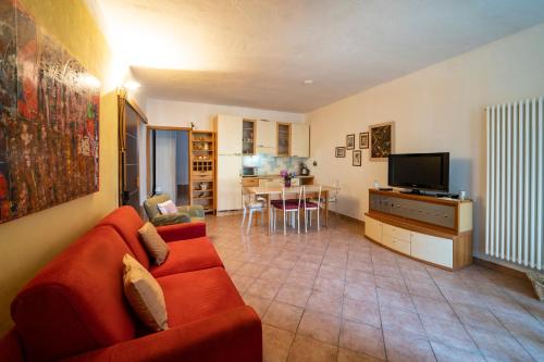 a living room with a red couch and a television at PANORAMIC GREEN VALLEY in Sulzano