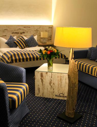 a hotel room with a couch and a table with a lamp at Hotel & Restaurant Seebrücke in Zingst