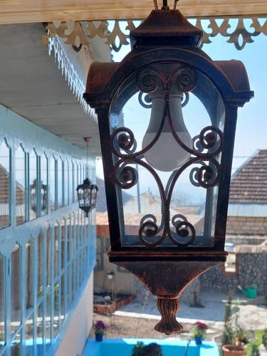 a black lantern hanging from a railing on a porch at Guest House Ruh Achari in Sheki