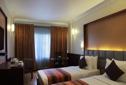 Llit o llits en una habitació de Regency Hotel