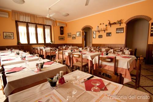 una sala da pranzo con tavoli e sedie con tovaglie bianche di Affittacamere Trattoria Del Cristo a Ospedaletto Lodigiano