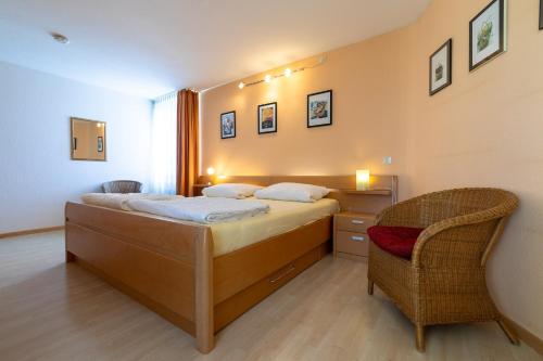a bedroom with a bed and a chair in it at Ferienwohnpark Immenstaad am Bodensee Zwei-Zimmer-Apartment 51 07 in Immenstaad am Bodensee