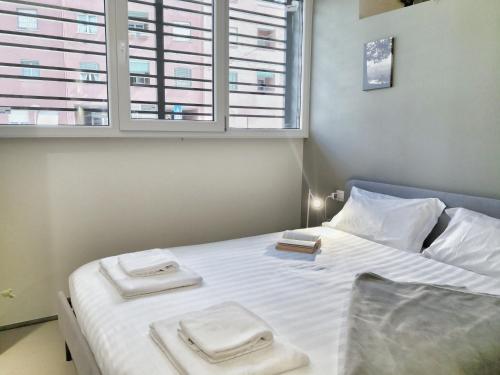 1 dormitorio con 1 cama con 2 toallas en Luxury Apartament - Graziano 39 - 2, en Milán