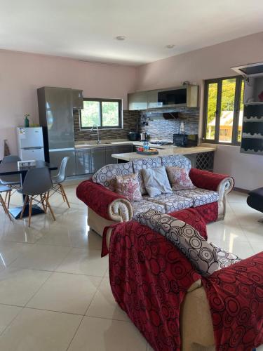 a living room with two couches and a kitchen at La Casa Apartment - Family Suite in Port Louis