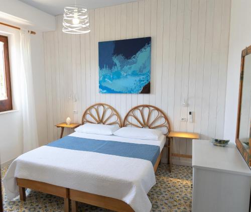 a bedroom with a bed with a blue and white blanket at L'Aurora Scala Dei Turchi in Realmonte