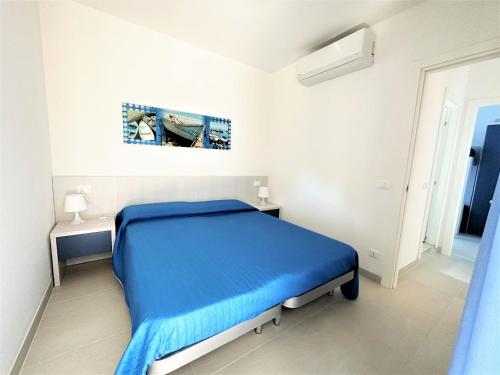 a bedroom with a blue bed in a white room at Residence Acapulco in Bibione