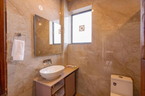 a bathroom with a sink and a mirror at Kailasham Stay in Dharamshala