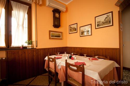 a dining room with a table and a clock on the wall at Affittacamere Trattoria Del Cristo in Ospedaletto Lodigiano