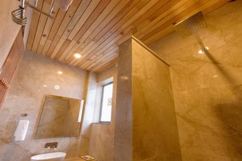 a large bathroom with a sink and a mirror at Kailasham Stay in Dharamshala