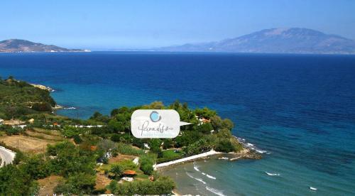 Eine Insel im Ozean mit einem Schild, das das Paradies liest in der Unterkunft Paradisso Beach Villas in Ammoudi