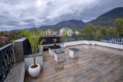 a balcony with benches and a view of mountains at Kailasham Stay in Dharamshala