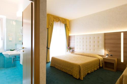 a hotel room with a large bed and a large window at Hotel Capri in Bardolino