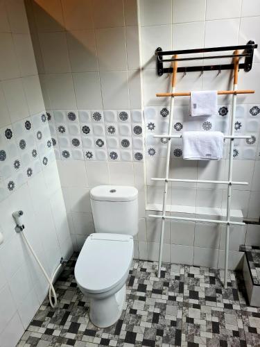 a bathroom with a white toilet and towels at Beach House Penida in Nusa Penida