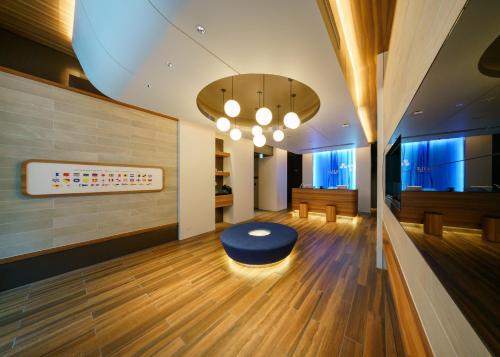 um lobby com um otomano azul no meio de uma sala em HOTEL SAILS em Osaka