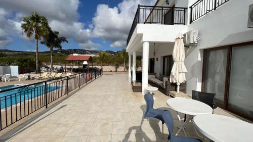 a patio with tables and chairs next to a pool at Nayia Paradise Villa! Best Villa in Cyprus in Paphos City