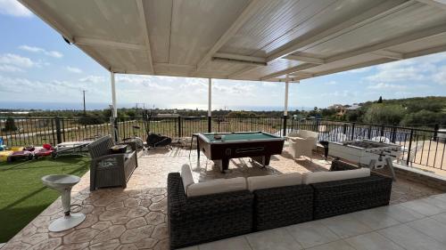 a patio with couches and a pool table at Nayia Paradise Villa! Best Villa in Cyprus in Paphos City
