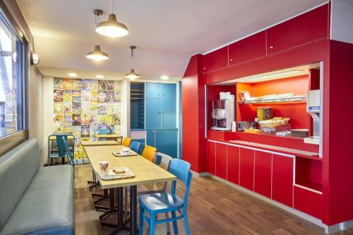 een restaurant met rode muren en een tafel en stoelen bij hotelF1 Epinay sur Orge in Épinay-sur-Orge