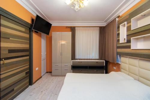 Un pequeño dormitorio con una cama y un televisor. en Cozy central flat in Varna Downtown, en Varna