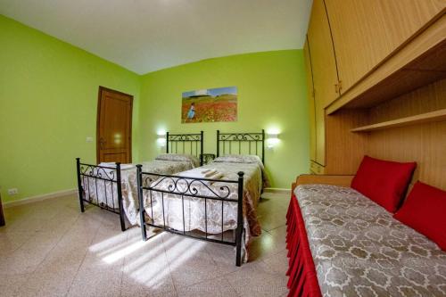 two beds in a room with green walls at La Cascina delle Viole in Norcia