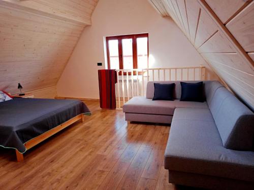 a room with a bed and a couch in a attic at Murań1 in Bukowina Tatrzańska