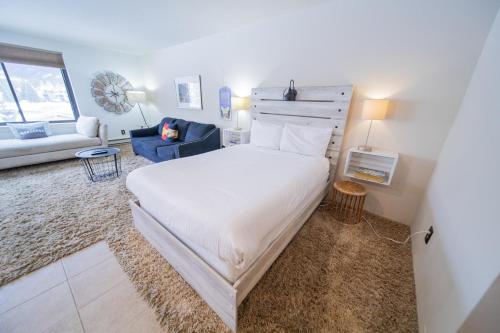 a bedroom with a large white bed and a blue chair at Edgewater 1436 in Keystone