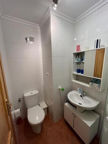 a white bathroom with a toilet and a sink at Apartamento Lagos Azules II in Ruilobuca