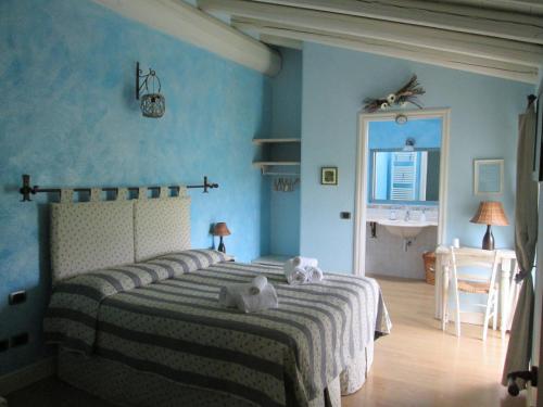 a bedroom with a large bed with blue walls at B&B Il Filo' in Valeggio sul Mincio