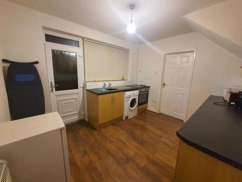 a kitchen with a sink and a washing machine at Spacious Double Bedroom Manchester in Middleton