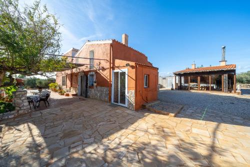 a house with a stone driveway in front of a building at Hauzify I Mas Bomba in Les tres Cales
