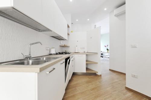 a kitchen with white cabinets and a sink at [Relax-Comfort-Home] City Center in Porto Torres
