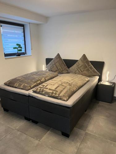 a large bed in a bedroom with a window at Ferienwohnung Emilia in Cologne