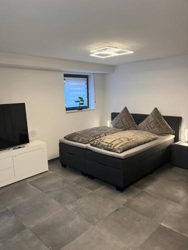 Schlafzimmer mit einem Bett und einem Flachbild-TV in der Unterkunft Ferienwohnung Emilia in Köln