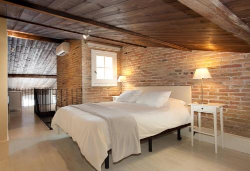 バルセロナにあるAB Poble Nou Veneroのレンガの壁に大きなベッドが備わるベッドルーム1室が備わります。