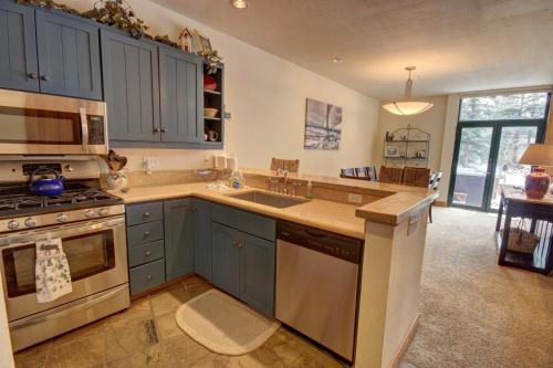 een keuken met blauwe kasten en een wastafel bij Ski Tip Ranch 8701 in Keystone