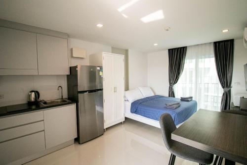 a small kitchen with a bed and a refrigerator at Mantra Beach Condominium Suite - Mae Phim in Ban Tha Fat