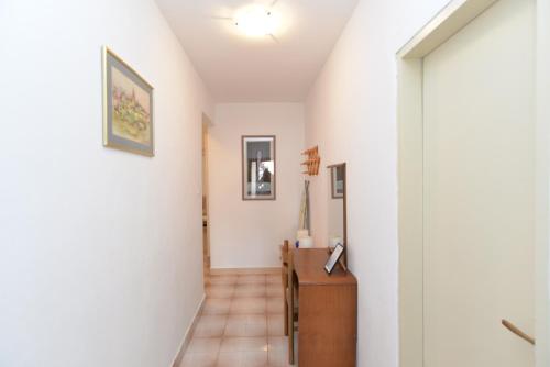 a hallway of a home with white walls and tile floors at Apartments Pietro 2228 in Bale