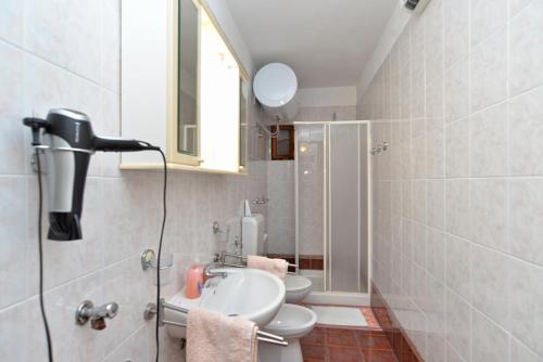 a bathroom with a sink and a toilet and a mirror at Apartments Pietro 2228 in Bale