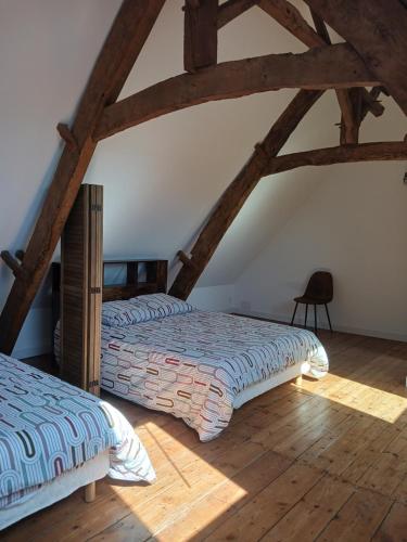 two beds in a attic room with wooden floors at Maison Centre d'Hillion, a 300 M de la plage de l'Hôtellerie,jardin clos ,animaux bienvenus in Hillion