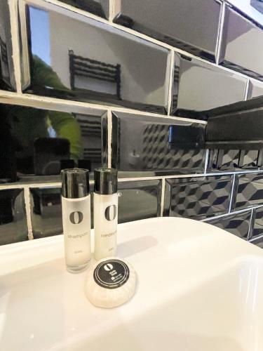 two bottles ofodorizers sitting on top of a bathroom sink at Loox Ostrovo- Boutique House-noclegi nad morzem in Ostrowo