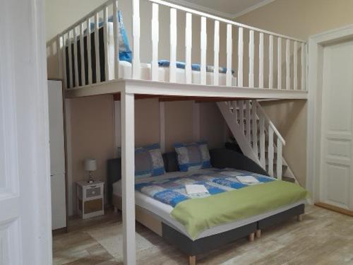 a bedroom with a bunk bed and a staircase at Edina Apartman in Sátoraljaújhely