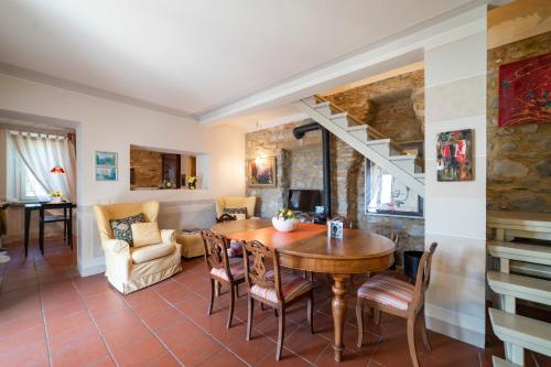 - un salon avec une table et des chaises ainsi qu'un escalier dans l'établissement VILLA ALTA ECO&LUXURY, à Provaglio d'Iseo